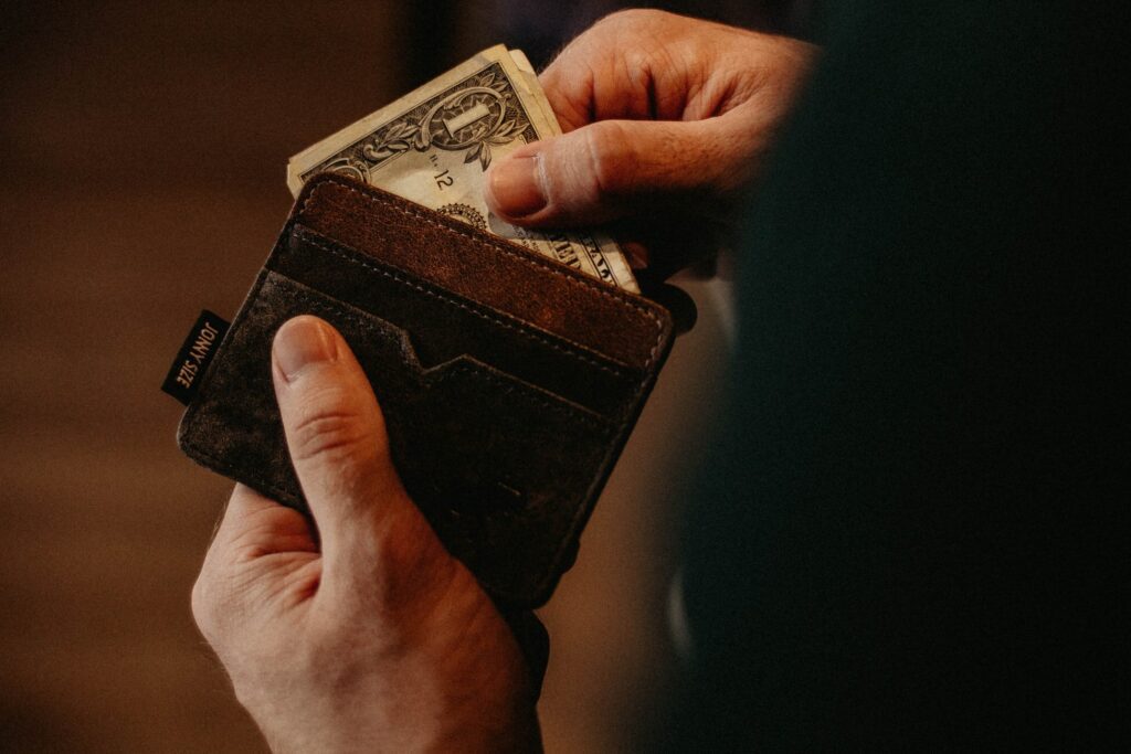 Man looking in wallet for money.