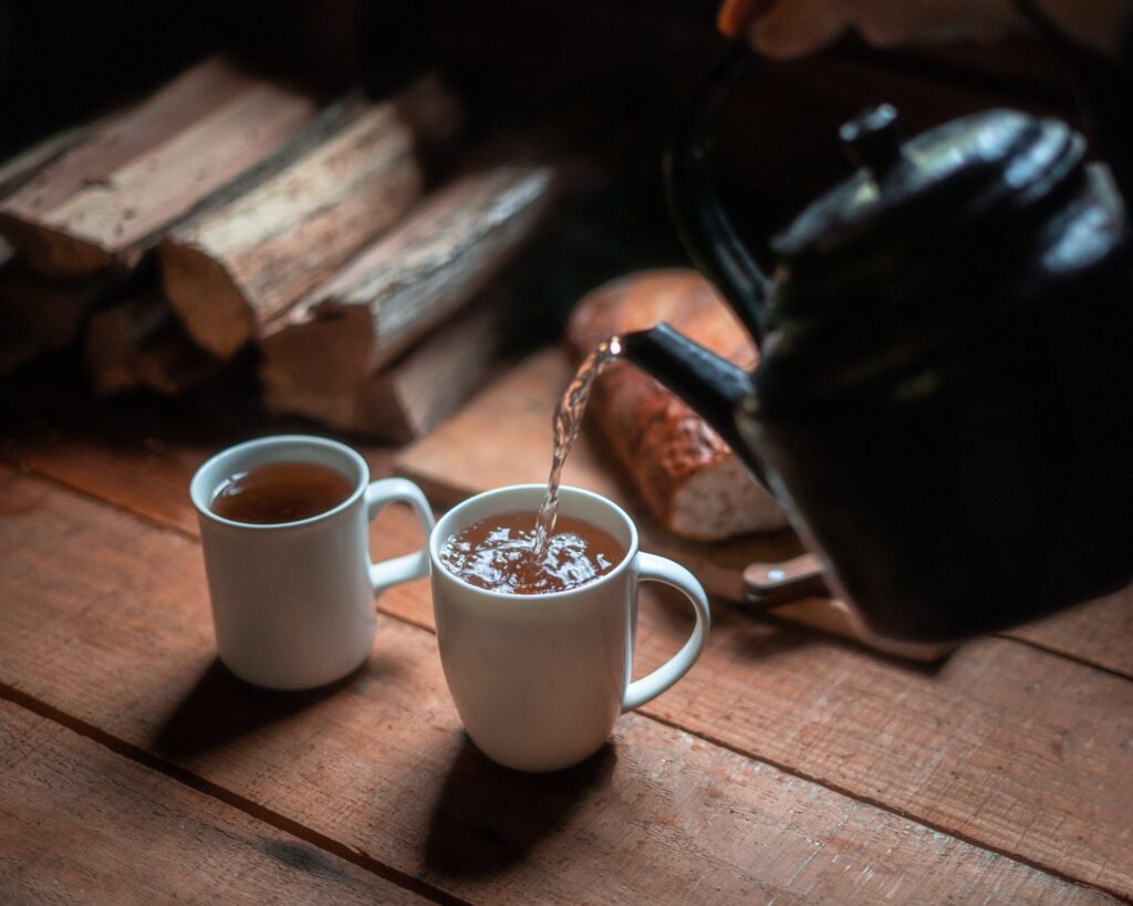 Fresh hot cascara coffee berry/cherry tea being poured into mugs.