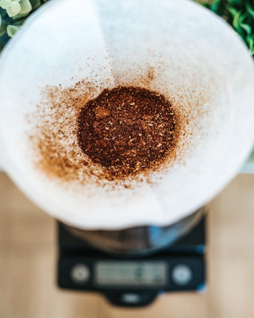 Dry gourmet coffee grounds resting in a pour-over filter waiting to be brewed.