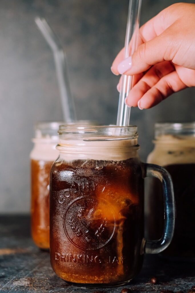 A cold, frosty glass of refreshing specialty cold brew coffee with a bit of sweet foam added to the top.