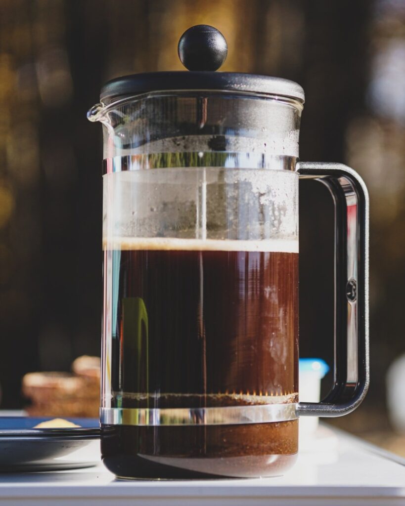 A French Press coffee brew device steeping hot and fresh, specialty coffee.