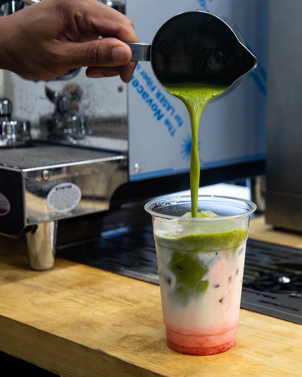 Daniel pouring a beautiful, icy, cold and refreshing strawberry matcha latte.